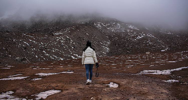 Personne marchant sur un paysage aride et rocheux.