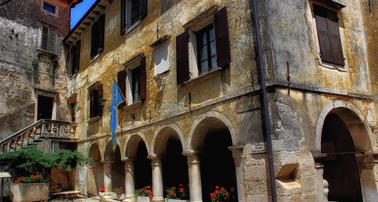 Bâtiments historiques avec des arches sur une place de ville pittoresque.