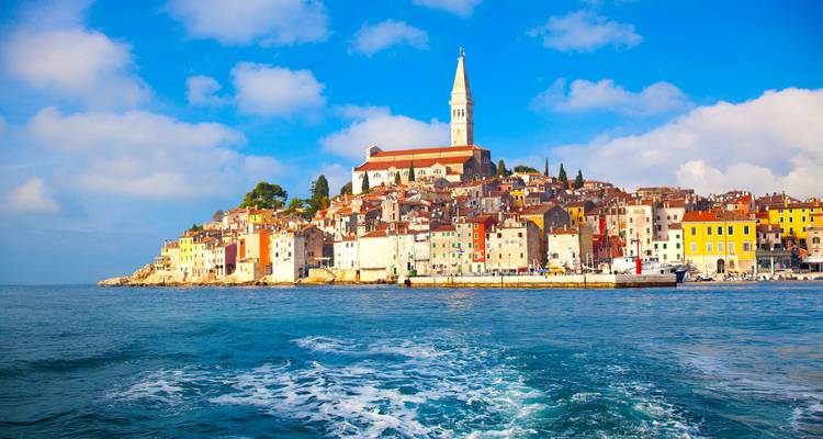 Seaside town with church tower seen from the water.