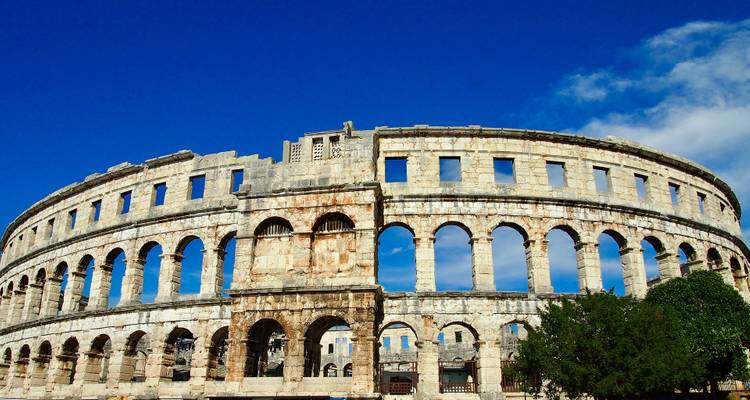 Roman amphitheater against a clear blue sky.