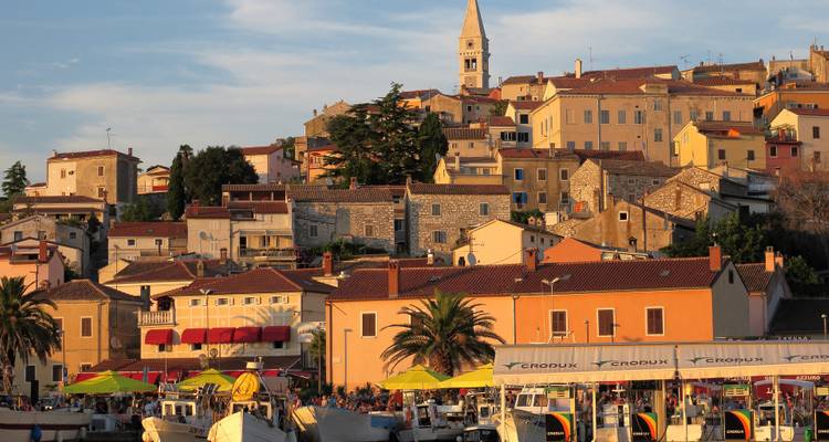 Scenic view of a town by the sea during sunset.