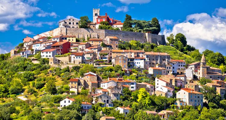 Charming hilltop town with colorful buildings and green surroundings.