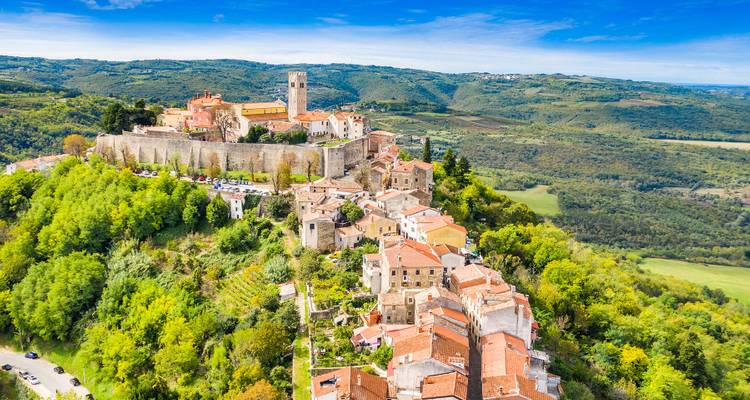 Aerial view of a historic town with a castle and surrounding landscape.