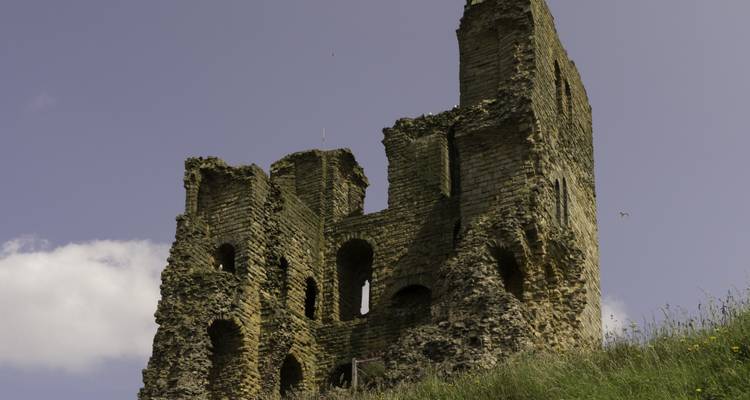 Ruines de pierre d'un château se détachant contre le ciel.