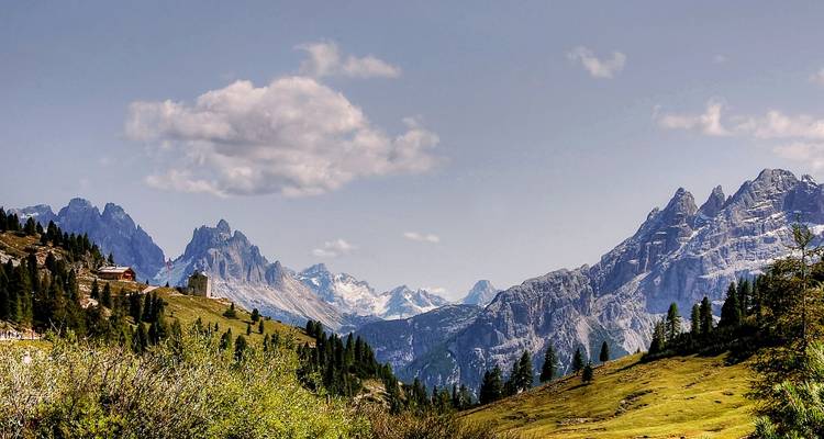 Paysage de montagne avec ciel bleu et nuages épars.