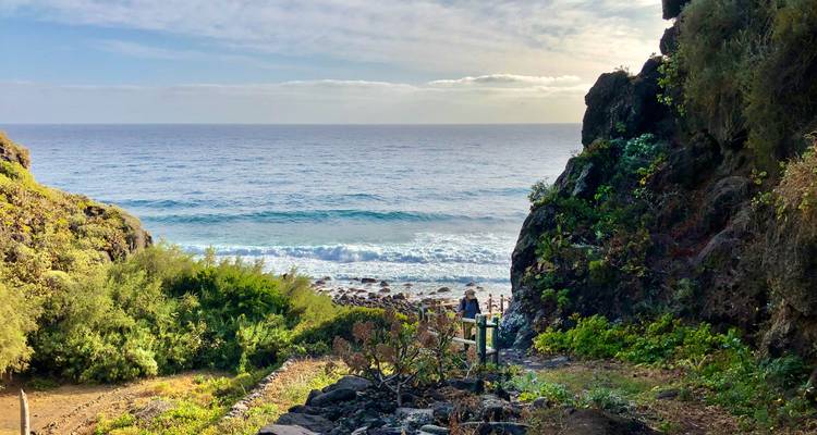 Vue sur la plage avec des vagues qui s'écrasent contre le rivage, vue entre les rochers.