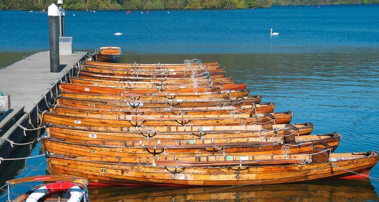 Barques à rames amarrées à une jetée avec une eau tranquille.