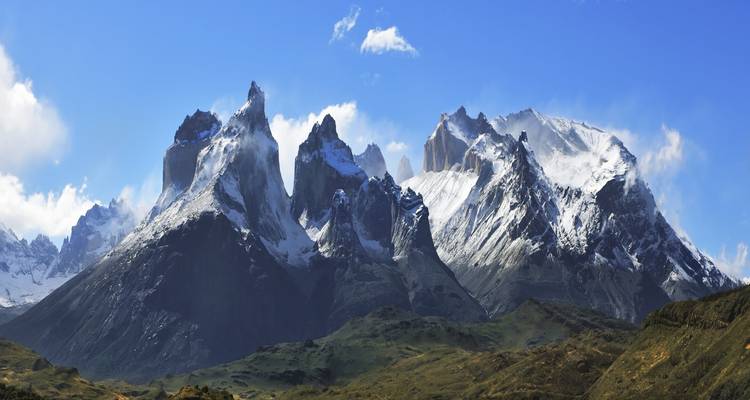 Panorama de montagnes enneigées sous un ciel bleu dégagé.