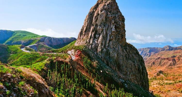 Pic rocheux proéminent dans un paysage aride.