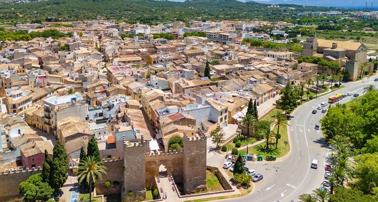 Vue aérienne d'une ville historique avec une muraille d'enceinte et des tours.