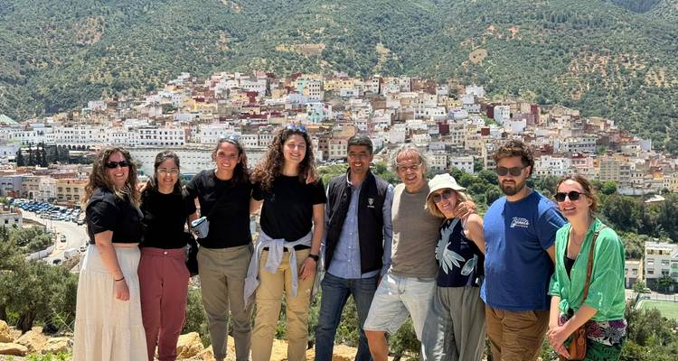 Gruppe von Touristen mit Panoramablick auf eine marokkanische Stadt im Hintergrund.