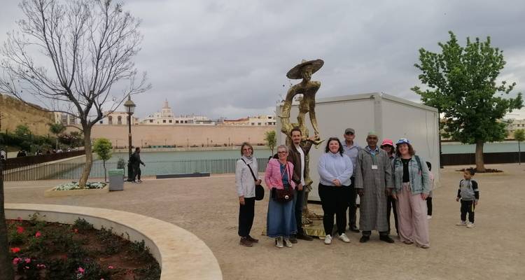 Touristen posieren in der Nähe eines Sees mit historischen Gebäuden im Hintergrund.