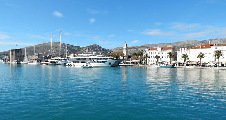 Waterfront van Trogir met jachten, middeleeuwse toren en witgekalkte gebouwen weerspiegeld in kalm water