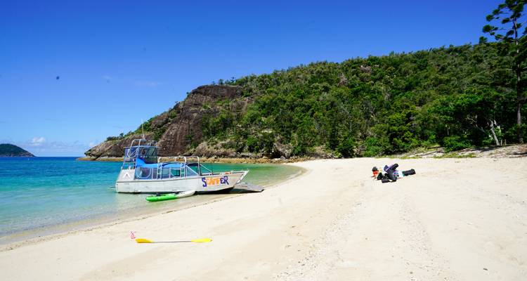 Empty beach with a boat docked on the sand.