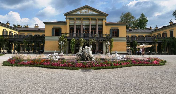 Villa élégante avec une fontaine et des jardins.