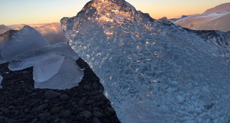 Gros plan de formations de glace scintillantes sur des galets.