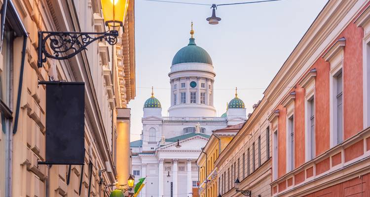 Die grüne Kuppel der Helsinkier Kathedrale erhebt sich über pastellfarbenen Straßen im sanften Abendlicht.