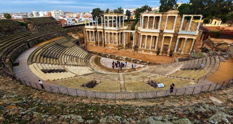 Anfiteatro romano antiguo con personas visitando.
