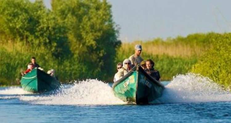 Here is the Dutch translation:
Mensen in kleine boten die door een weelderige, groene waterweg navigeren.