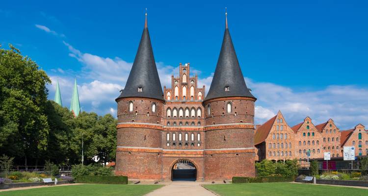 Historische poort met kegelvormige torens onder een heldere blauwe hemel.