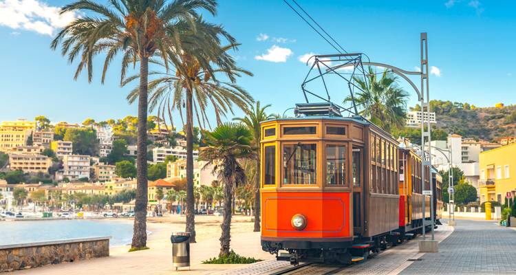 Historic tram along a waterfront.