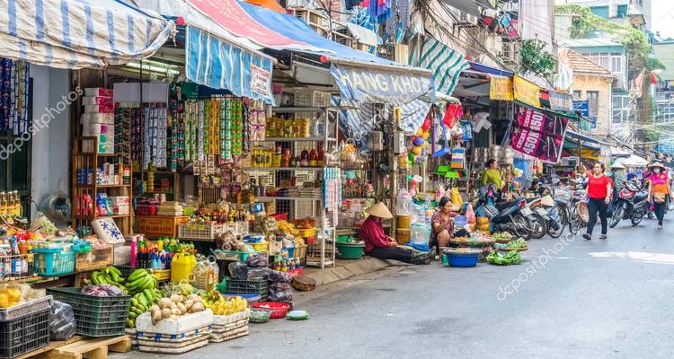 Drukke straatmarkt met kleurrijke kramen en mensen.