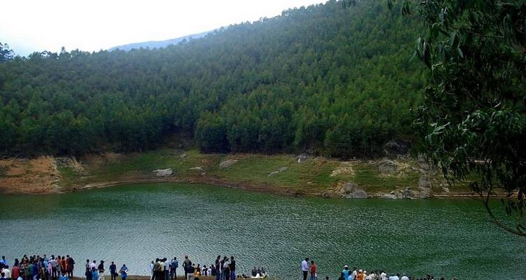 People by a lake surrounded by hills.

**Dutch translation:**
Mensen bij een meer omringd door heuvels.