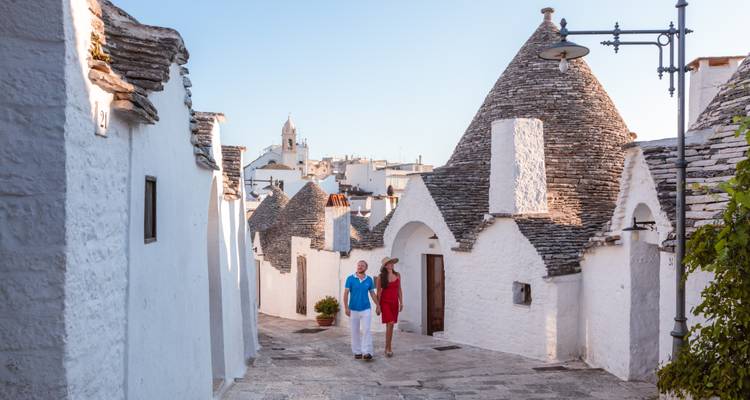 Couple walking through Alberobello's trulli houses.