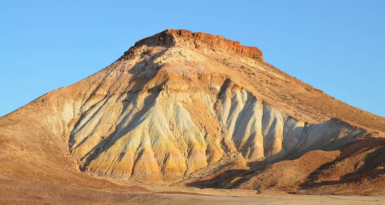A striking, layered mountain peak in a desert environment.