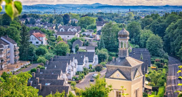 Un paysage urbain avec un clocher d'église visible et des maisons d'habitation.