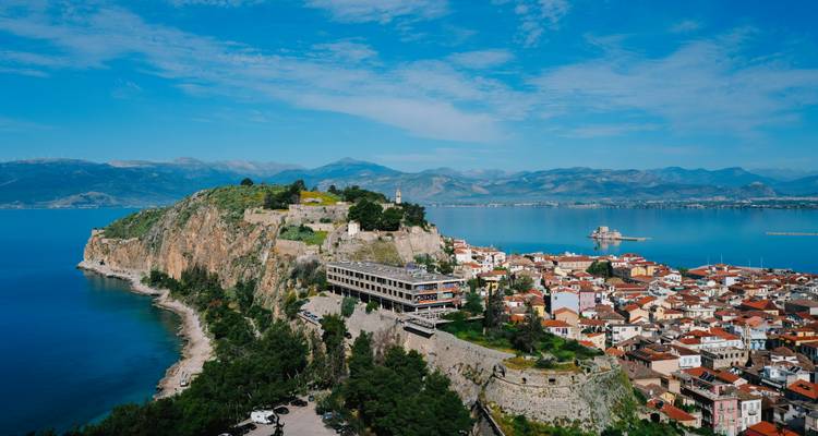 Vue côtière de la ville de Nauplie avec une forteresse sur une colline.