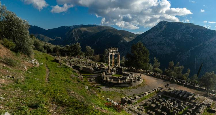 Ruines d'un site antique avec des montagnes en arrière-plan.