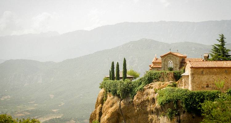 Paysage de montagne avec un petit monastère sur une falaise.