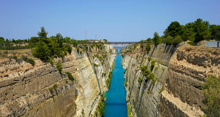Un canal avec de l'eau bleue claire et un pont au-dessus.