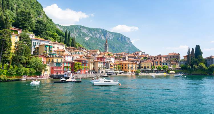 Charming lakeside town with colorful buildings and a mountain backdrop.