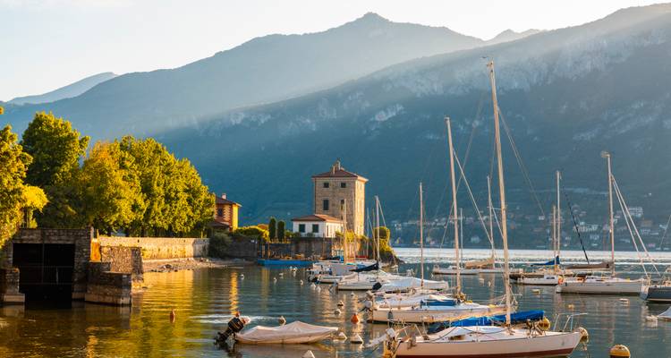 Vue du lac avec bateaux et montagnes lointaines.