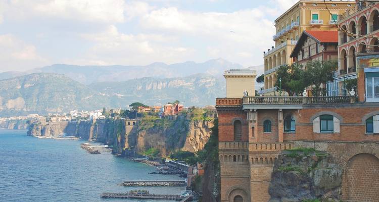 Dramatische Küstenklippen von Sorrento, gesäumt von historischen Gebäuden mit Blick auf das blaue Tyrrhenische Meer.