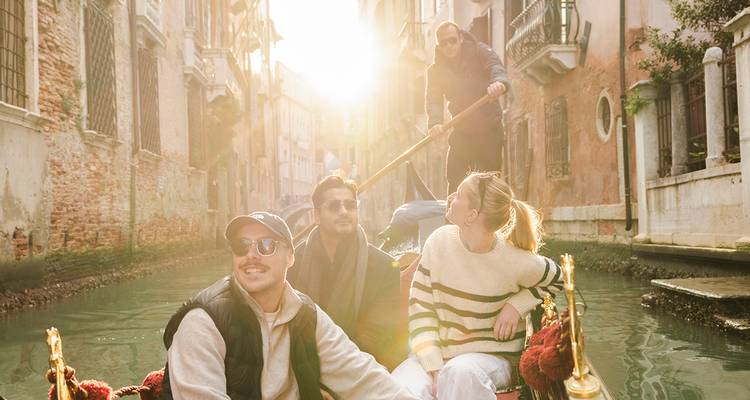 Paseo en góndola bajo el sol con amigos navegando por un tranquilo canal veneciano en la hora dorada.
