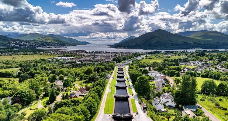 Vista aérea de las compuertas de la Escalera de Neptuno que se extiende hacia el Loch Linnhe rodeada de un paisaje verde exuberante y montañas distantes.