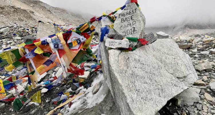 Een grote rots met gebedsvlaggen en de inscriptie 'Everest Base Camp 2017'.