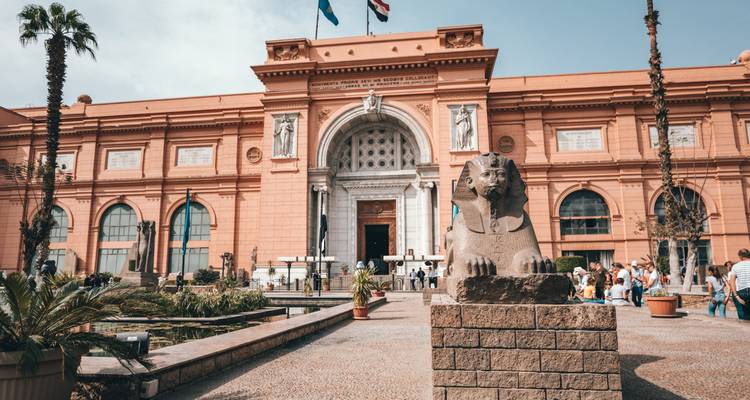 Toeristen buiten een historisch museumgebouw.