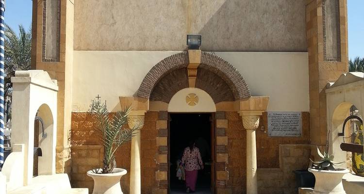 Person entering a building with an arched doorway.