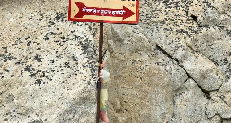 Wegweiser neben einer felsigen Oberfläche.