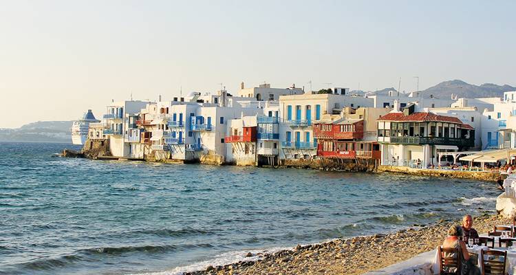 Les bâtiments emblématiques blancs et bleus au bord de l'eau de la Petite Venise à Mykonos bordent la mer Égée.