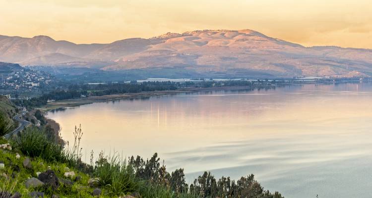 Vista panorámica de un lago y montañas durante el atardecer.