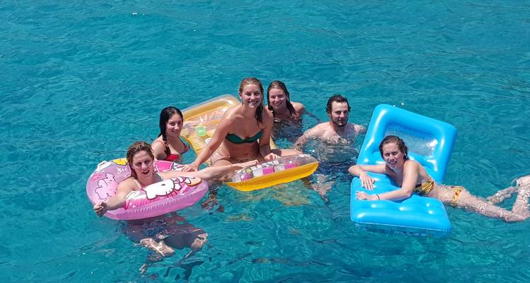 Group of people enjoying floating lounges in a pool.