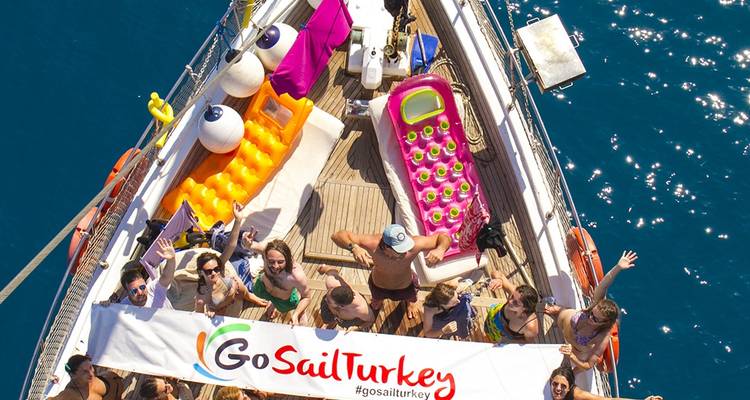 Group of people on a sailboat with GoSailTurkey banner.