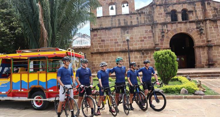 Des cyclistes posent avec leurs vélos devant une église historique.