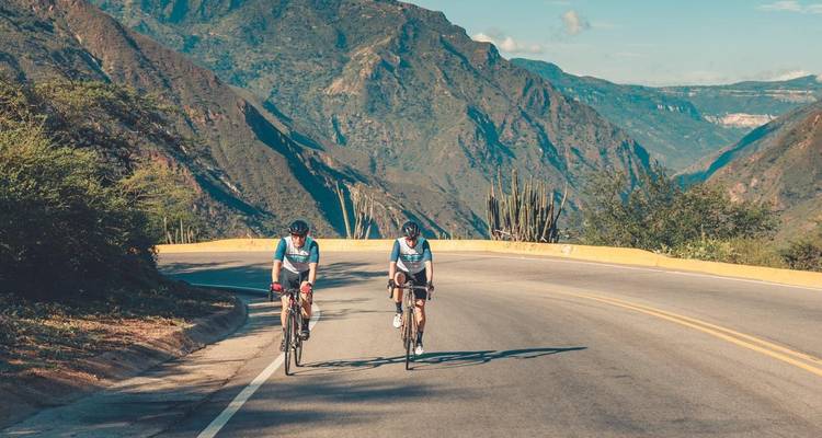 Deux cyclistes roulant le long d'une route de montagne avec un paysage magnifique.