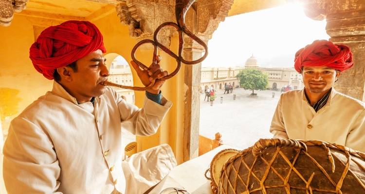Twee mannen in traditionele kostuums die genieten van een muzikaal moment.